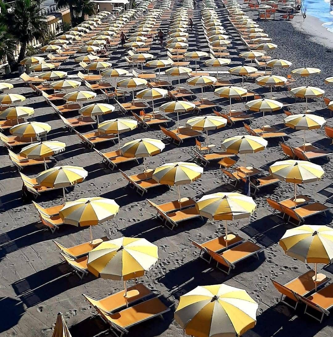 File di ombrelloni e lettini sulla spiaggia attrezzata dei Bagni Saitta nella Riviera delle Palme